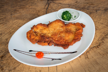 Chicken schnitzel. Chicken fillet, flour, egg, breadcrumbs. Garnished with ball oil and dill.