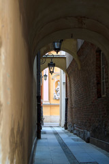 Fototapeta na wymiar narrow street with lamps to the St. Martin's Church architectural details in Warsaw Old Town