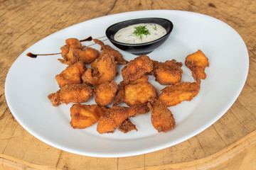 Crispy breaded chicken nuggets. Garnished with garlic-mayonnaise sauce with dill.