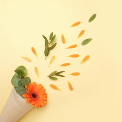 Fototapeta premium Flower composition on a yellow background. Gerberas, eucalyptus branches, petals. Flat lay, top view.