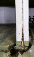 water damage in concrete construction with calcium and rust deposits and puddles