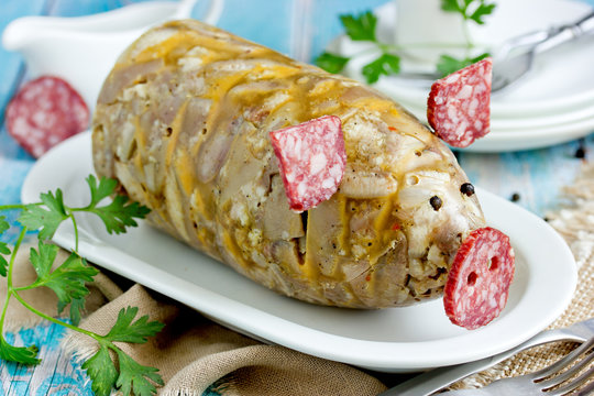 Russian dish holodets, headcheese, pork meat jelly, aspic in bottle shaped funny pig decorated with salami sausage and black pepper