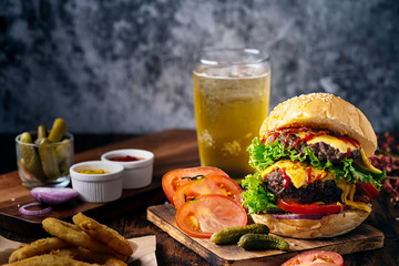 Fresh and juicy hamburger. Cheese burger with beef or bacon, patty tomato, onion ring and sparkling water or beer.