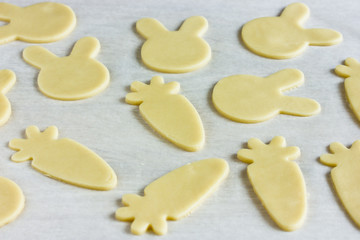 Fototapeta na wymiar Cooking traditional cookies shaped bunnies and carrots for Easter holiday