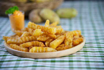 Delicious fried potato on wooden plate with dipped sauce - traditional fast food concept