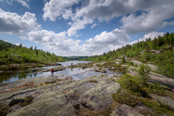 Girl hiker in red shirt standing in a beautiful lake landscape Norway