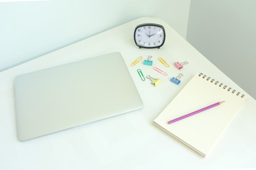 Laptop, stationery, office supplies on white modern home office desk workspace on pale blue and yellow pastel color background with copy space. Creative, freelance and minimal office. Retro interior.