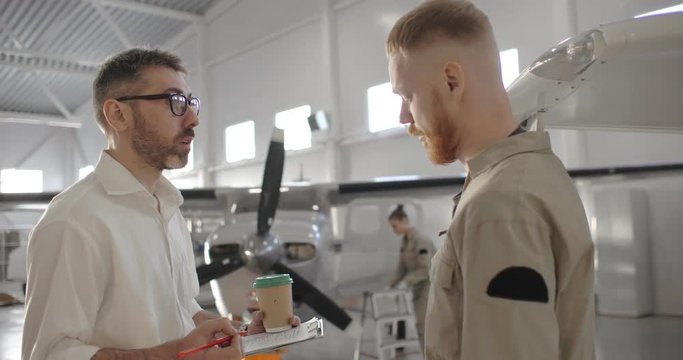 Portrait of aerospace engineer talking to aviator