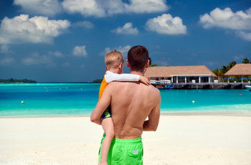 Toddler boy on beach with father