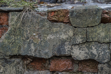 Old wall from a red brick shattered cracked plaster. Abstract background.