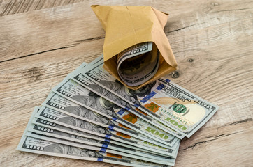 dollars in a paper bag on a wooden background