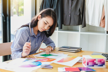 Young woman fashion designer working on her designs in the studio.