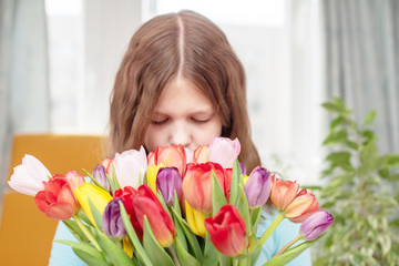 little girl and beautiful bouquet of colorful tulips
