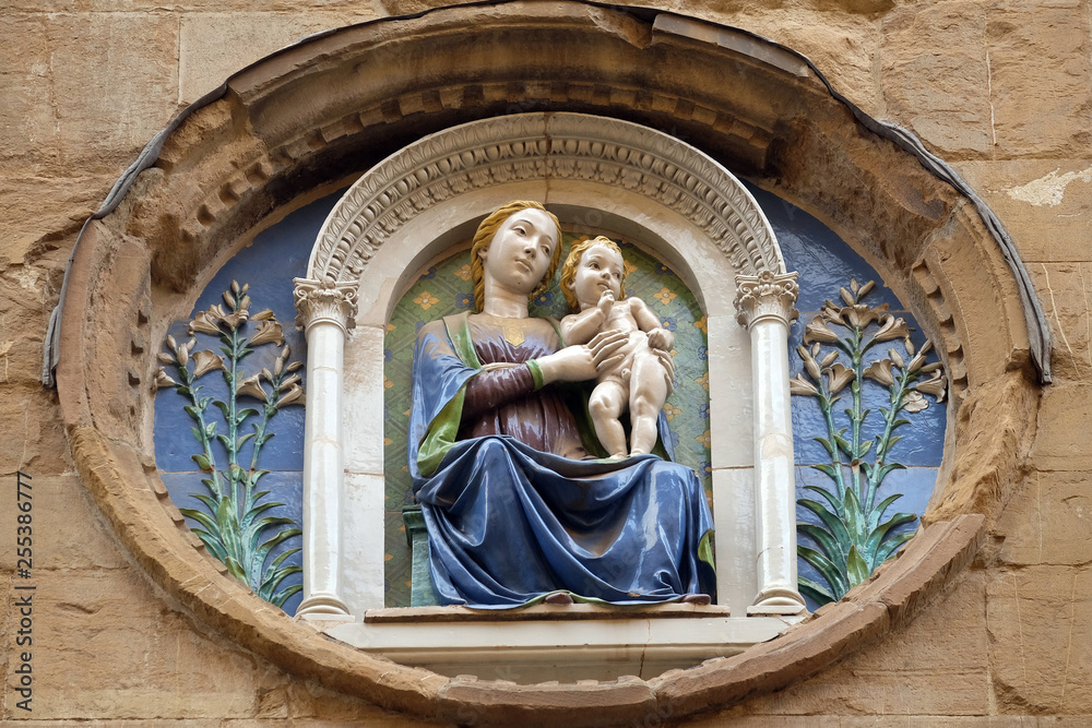 Wall mural Medallion with the Virgin Mary and Child by Luca della Robbia on the facade of Orsanmichele Church in Florence, Tuscany, Italy