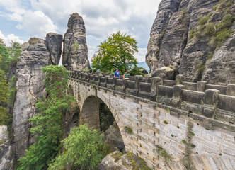 Fototapeta premium Rathen, Germany - The Bastei is a rock formation towering 194 metres above the Elbe River in the Elbe Sandstone Mountains, and one of the main attraction of the Saxon Switzerland National Park