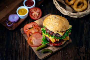 Fresh and juicy hamburger. Cheese burger with beef or bacon, patty tomato, onion ring and tomato sauce or ketchup.