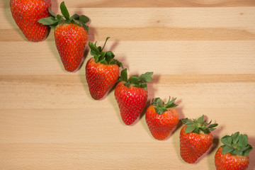 Strawberries on natural wooden background in diagonal pattern