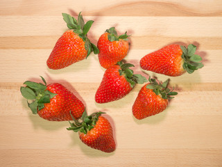 Strawberries on natural wooden table, top down view