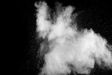 White powder explosion isolated on black background. White dust particles splash.Color Holi...