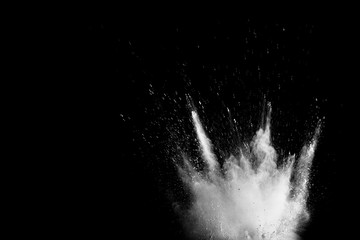 White powder explosion isolated on black background. White dust particles splash.Color Holi...
