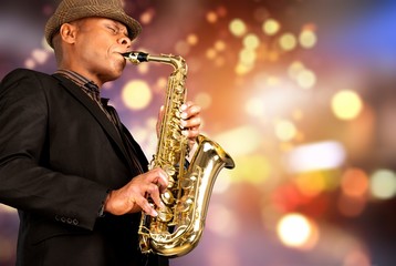 Fototapeta premium Close-up man playing on saxophone on blurred background