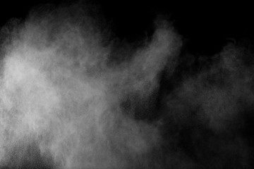Bizarre forms of white powder explosion cloud against black background.White dust particles splash.