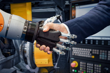 Hand of a businessman shaking hands with a Android robot.