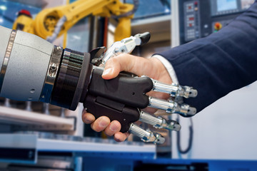 Hand of a businessman shaking hands with a Android robot.