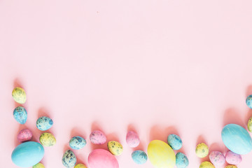 Fototapeta na wymiar Painted easter eggs lying on pink background
