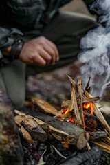 Man lighting a fire in a forest