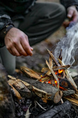 Man lighting a fire in a forest