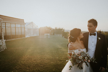 bride and groom kissing at sunset