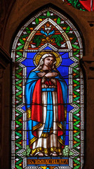 Fototapeta na wymiar Immaculate Conception, stained glass window in the Basilica di Santa Croce (Basilica of the Holy Cross) - famous Franciscan church in Florence, Italy