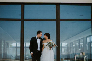 bride and groom in front of a window