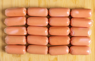 Small sausages on a plate on a cutting Board.