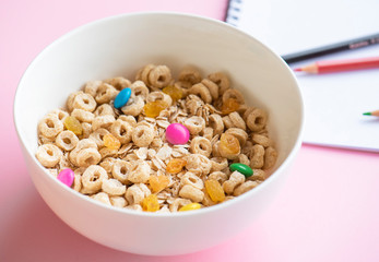 Cornflakes and oatmeal, in a white bowl, notepad and pencils. Diet concept. 