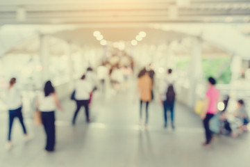 many people walking on the skywalk with blurry image