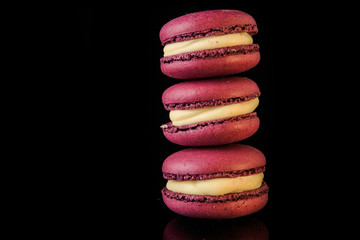 tower of three purple macaroons with yellow filling
