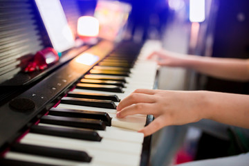 Obraz premium selective focus to kid's hand playing piano on stage
