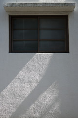 A window on a white concrete wall