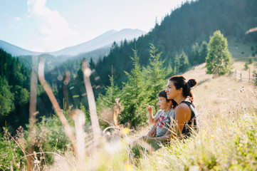 Young mom with baby boy travelling. Mother on hiking adventure with child, family trip in mountains. National Park. Hike with children. Active summer holidays. Fisheye lens