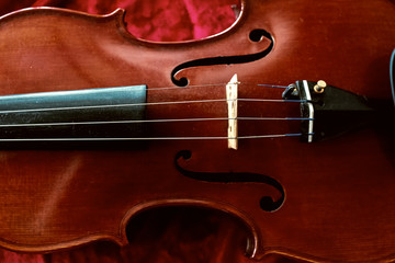 Obraz premium The classic violin put on red cloth,show detail of the instrument