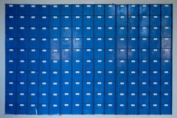 Wall of Antique  numbered locked boxes. Box doors are blue with keyhold, white frame border