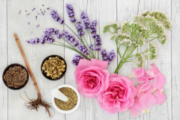 Obraz na płótnie Canvas Lavender, chamomile, rose, elderflower and valerian herbs. Used in alternative & traditional herbal medicine with the roots & flowers having many health benefits. Top view on rustic wood background.