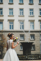 Fototapeta na wymiar Bride with bouquet in the city