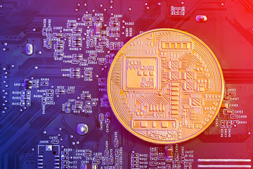 Concept of Bitcoin Mining. Golden Bitcoin on the microchip board close up.