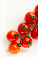 Vertical image with cherry tomatoes on white surface