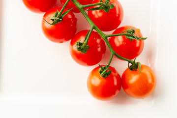 Top view of tasty tomatoes on the white plate on the table
