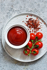 Classic tomato sauce with spices on a concrete background. View from above.