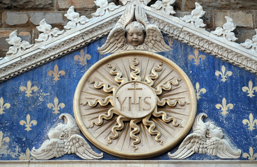 Medallion with the IHS monogram between two lions, above to the entrance to Palazzo Vecchio, a UNESCO World Heritage Site in Florence, Italy